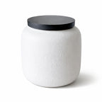 Witte keramische dierenurn met zwarte deksel en herdenkingshanger met pootafdruk.