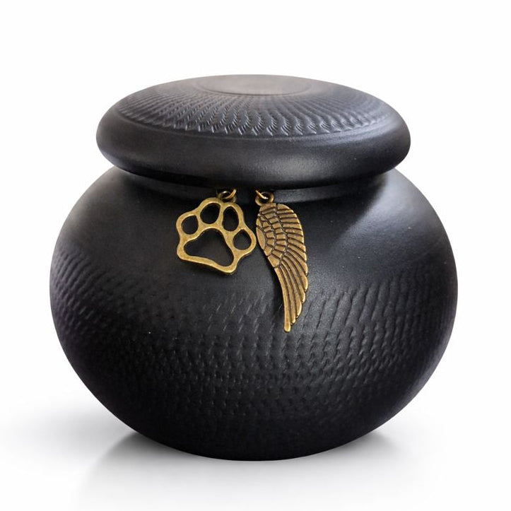 Matzwarte dierenurn met subtiele textuur en deksel met bronskleurige hangers