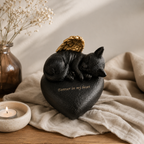 De laatste aai hartvormige urn voor katten in zwart resin met een slapend katje en gouden engelenvleugels- sfeerfoto