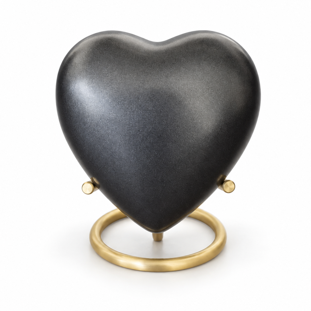 De laatste aai hartvormige mini urn in antraciet aluminium op een gouden standaard voor as van huisdieren