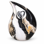 De laatste aai druppel urn met marmerlook in zwart, wit en goud met een glanzend zilveren hart als symbool.