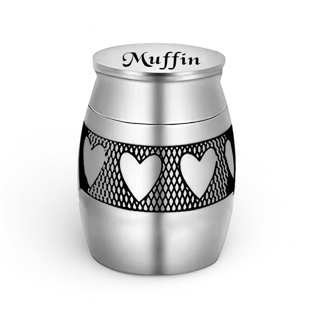 De laatste aai zilverkleurige RVS mini urn voor huisdieren met een gegraveerd hartjespatroon en naam Muffin op deksel